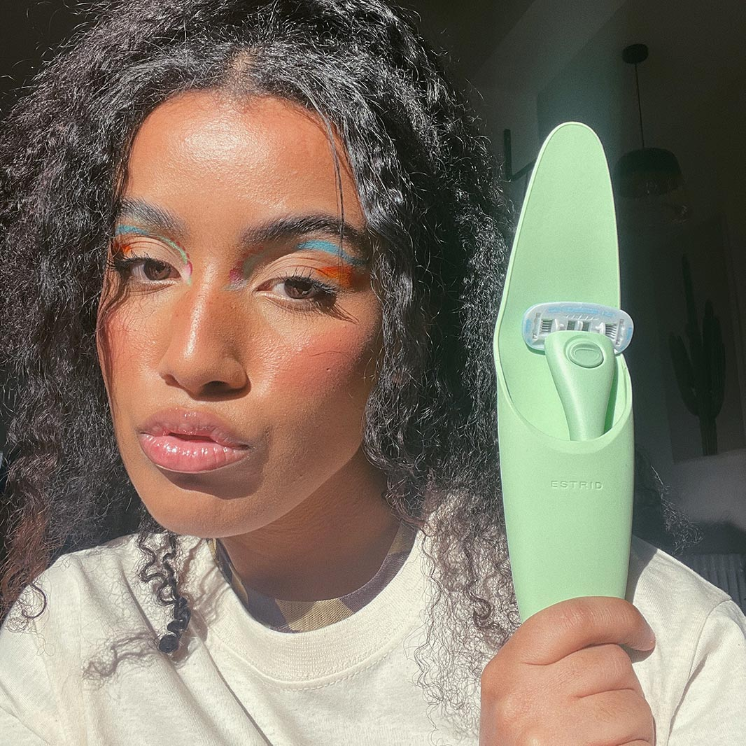 Woman with make-up showing a green razor in a green case 