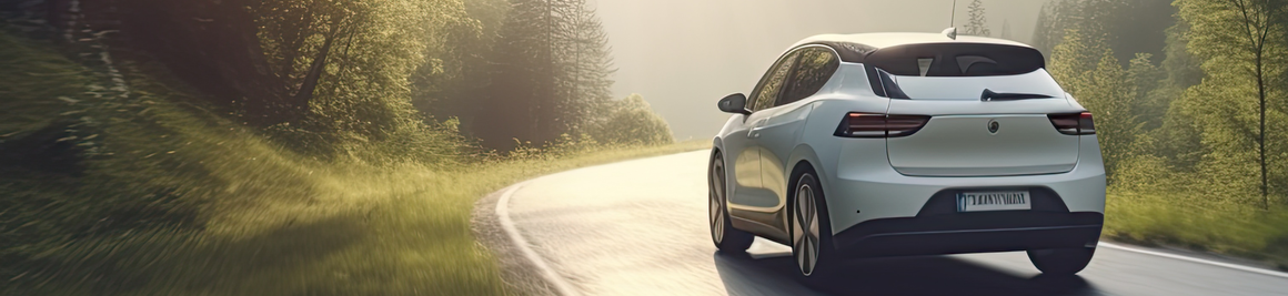 A white car driving on a winding road through a lush, sunlit forest with trees on both sides.