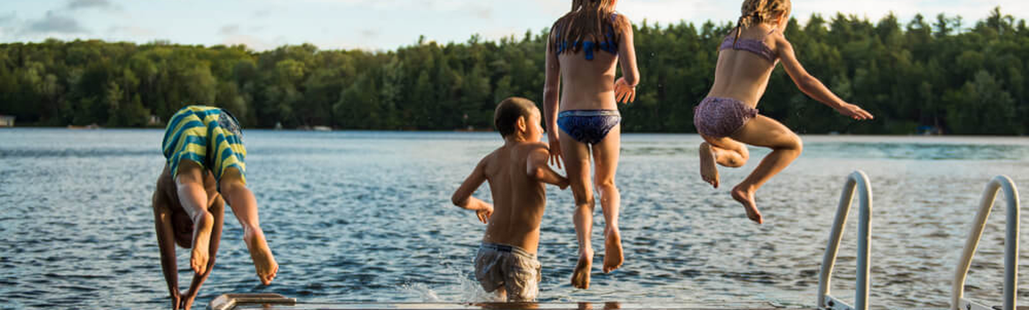 Děti skáčou do jezera