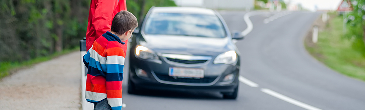 žena s dieťaťom a prichádzajúce auto
