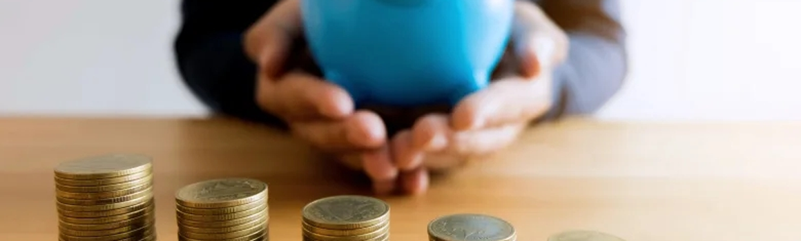 Muž s modrým prasiatkom a kôpka mincí