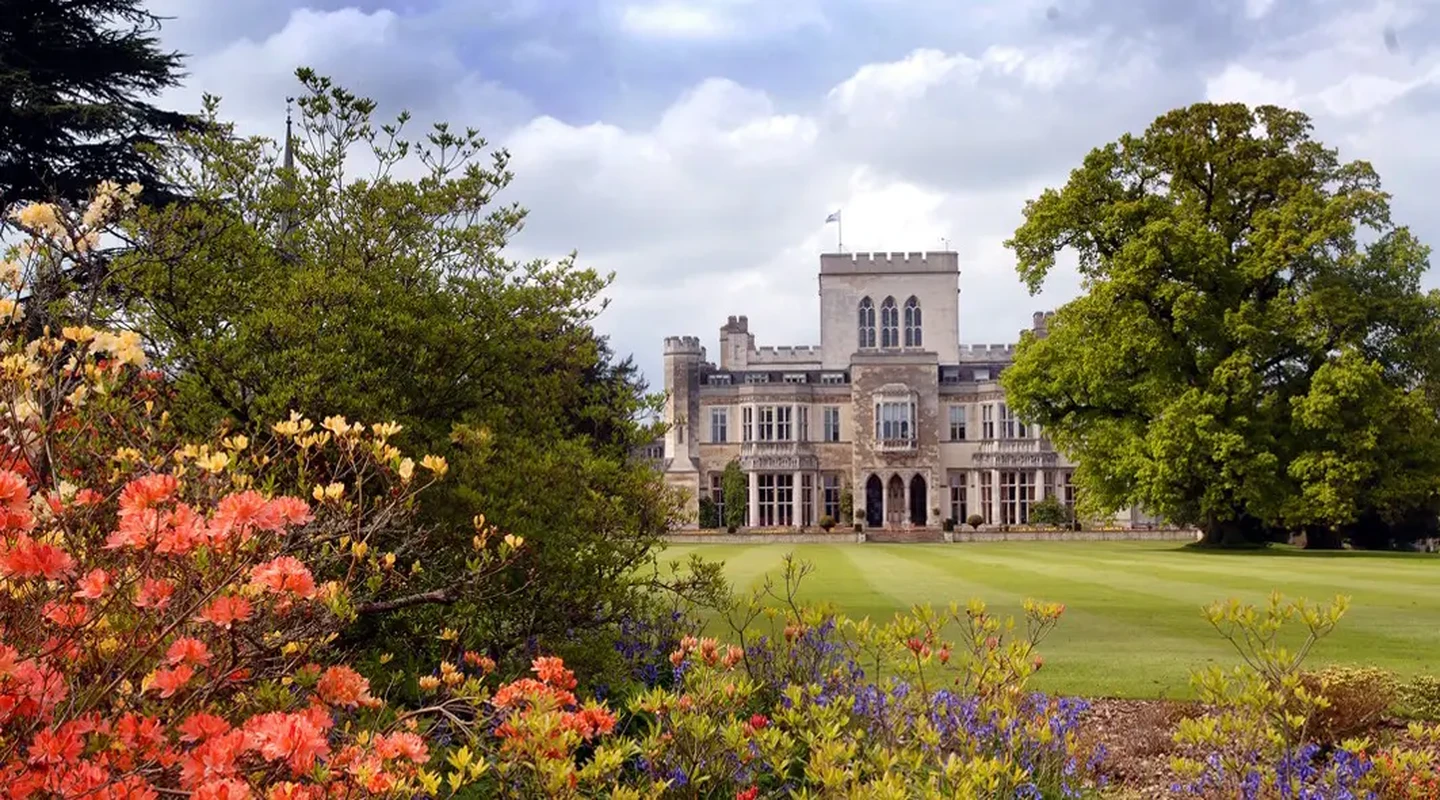 Summer flowers bloom on the lawn outside Ashridge House with the exterior of the house seen in the background