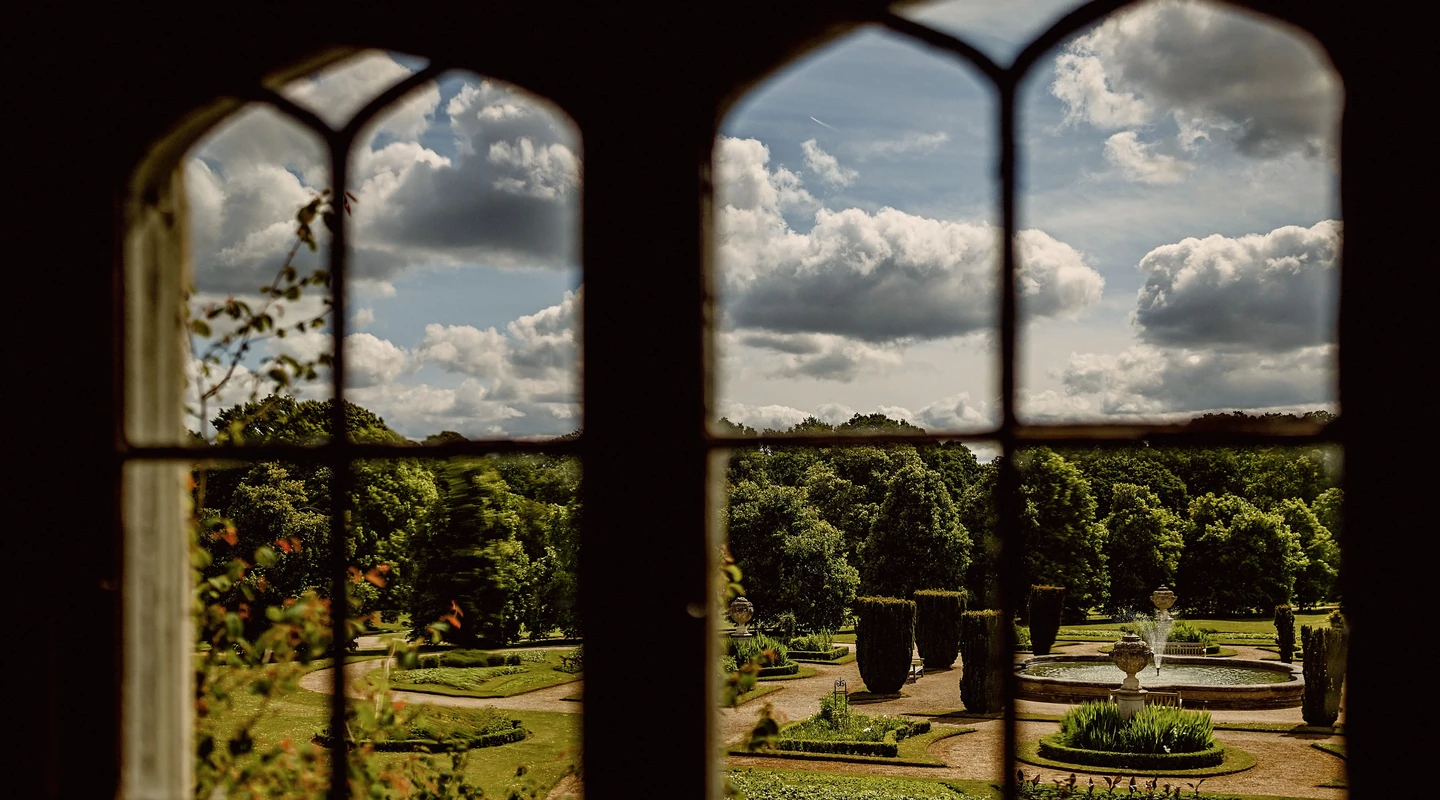 View through a window out into the Italian gardens and fountain