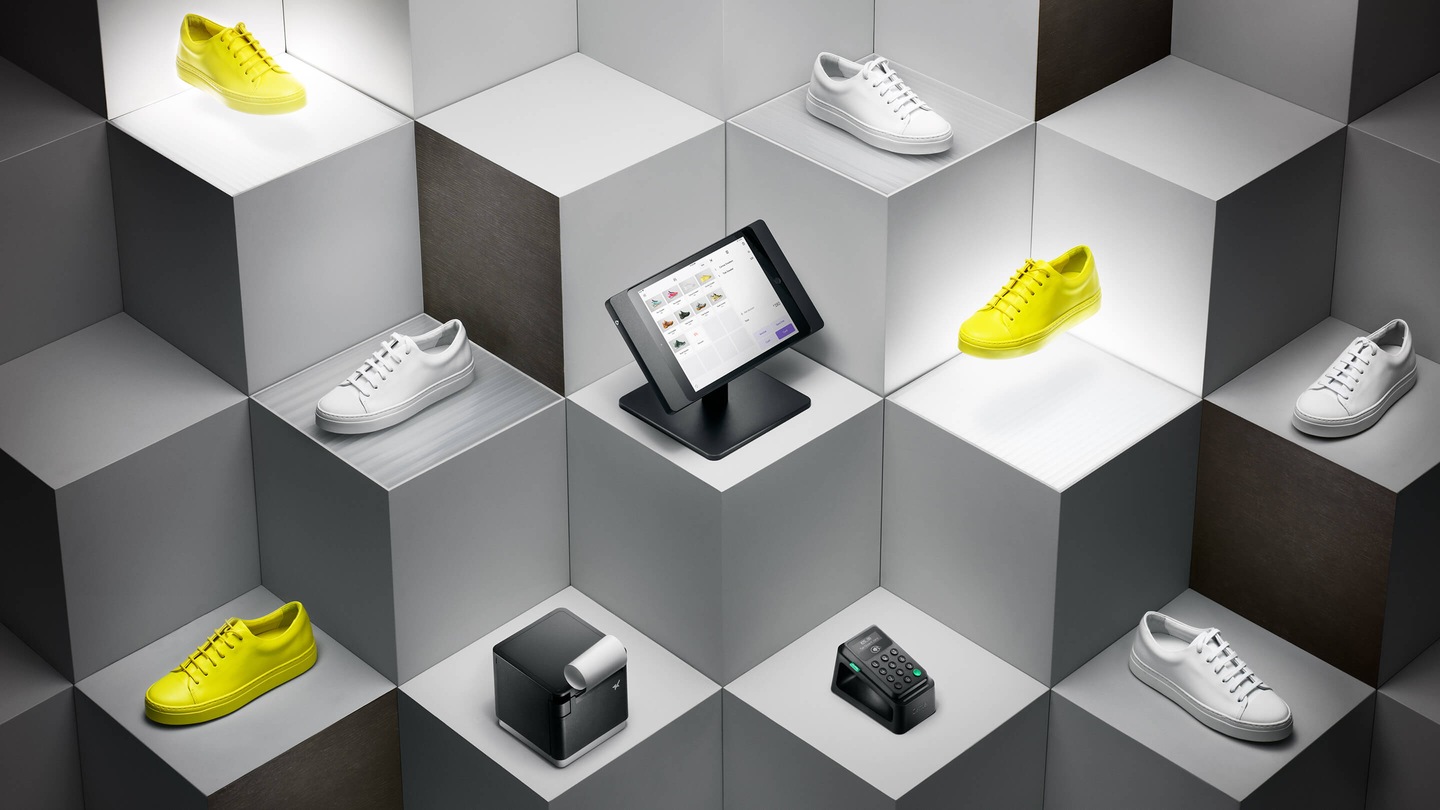 Stair-step blocks with yellow and white sneakers on them, with a black Zettle Reader and Dock, iPad Stand and Receipt printer on the blocks in the center