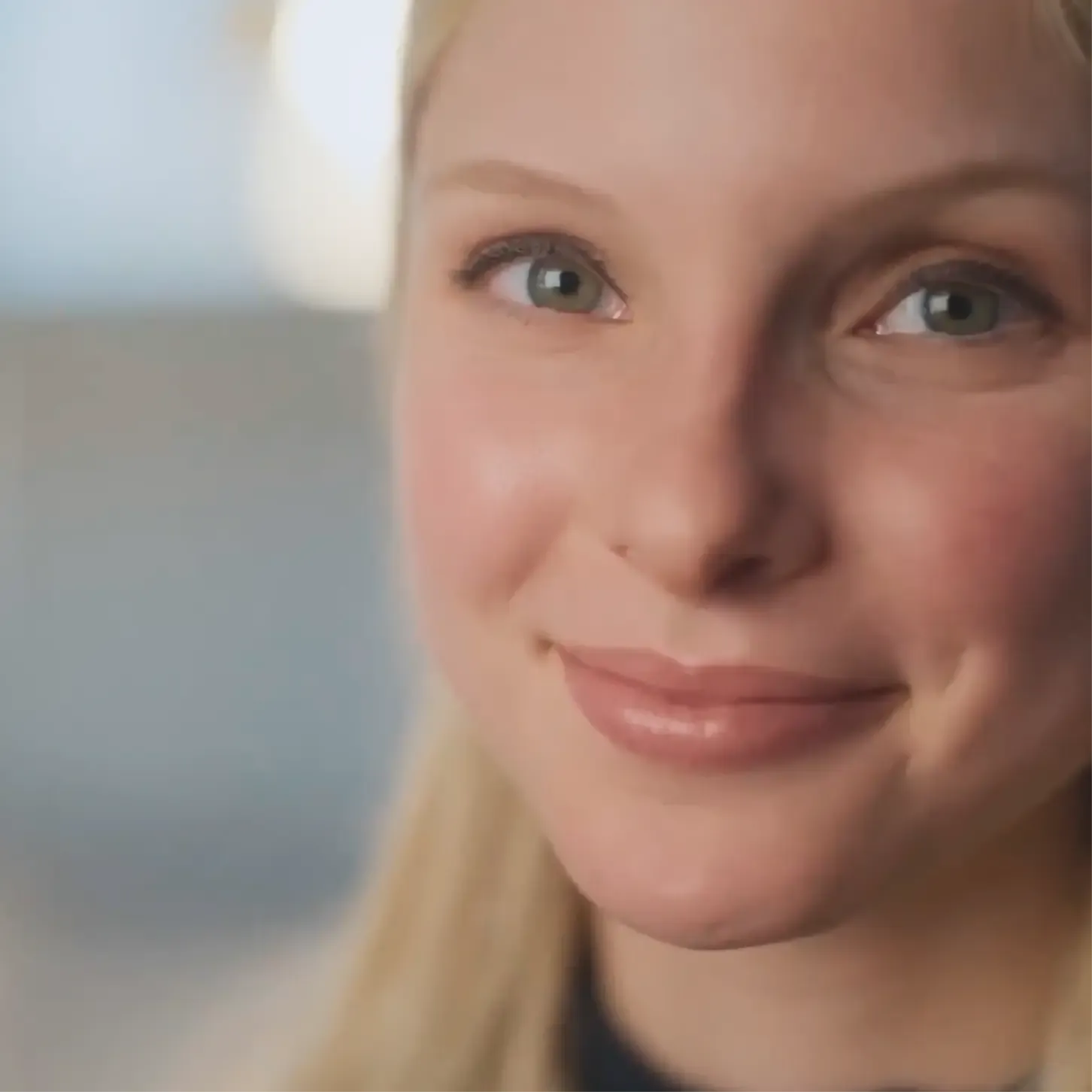Close-up of a young woman smiling softly, from Dove's Cost of Beauty film
