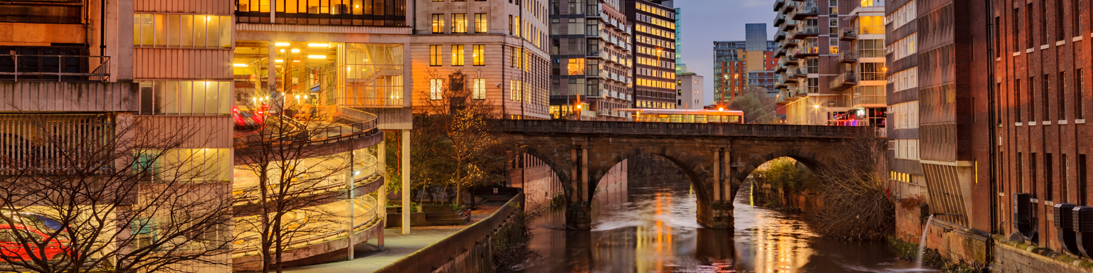 Modern apartments on both side of river Irwell passing through Manchester city center, UK.