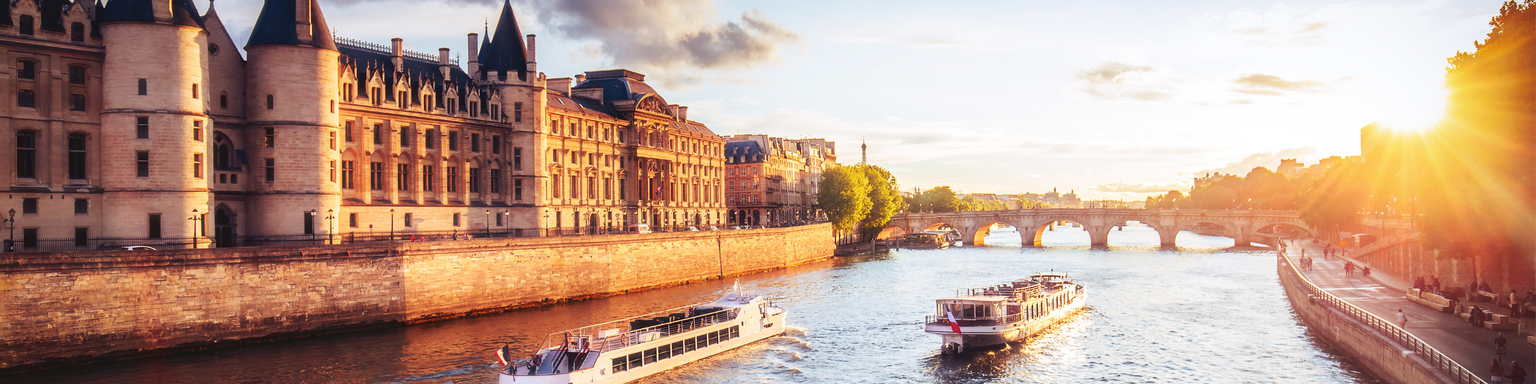 Dramatic sunset over river Seine in Paris, France, with Conciergerie and Pont Neuf. 