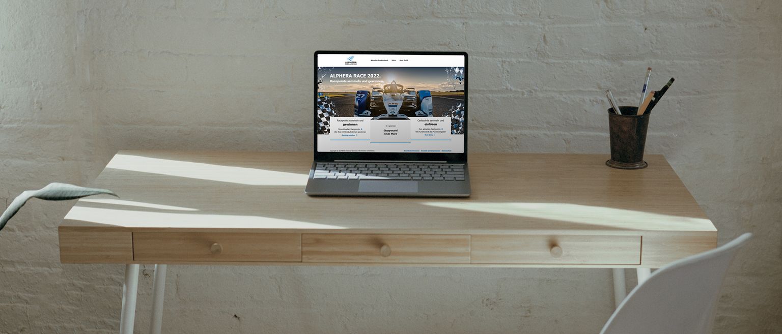 Schreibtisch mit Laptop mit Alphera Race Webseite