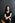 Bewerbungsfoto Frau sitzt auf Holzstuhl dunkler Hintergrund ernstes Portrait