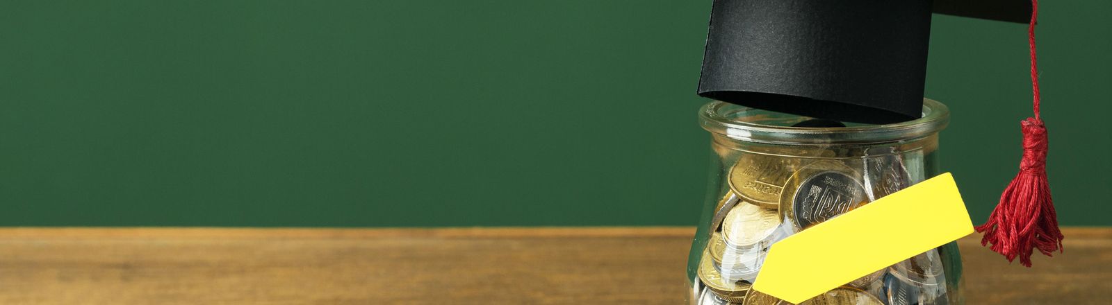front-view-jar-with-coins-academic-cap