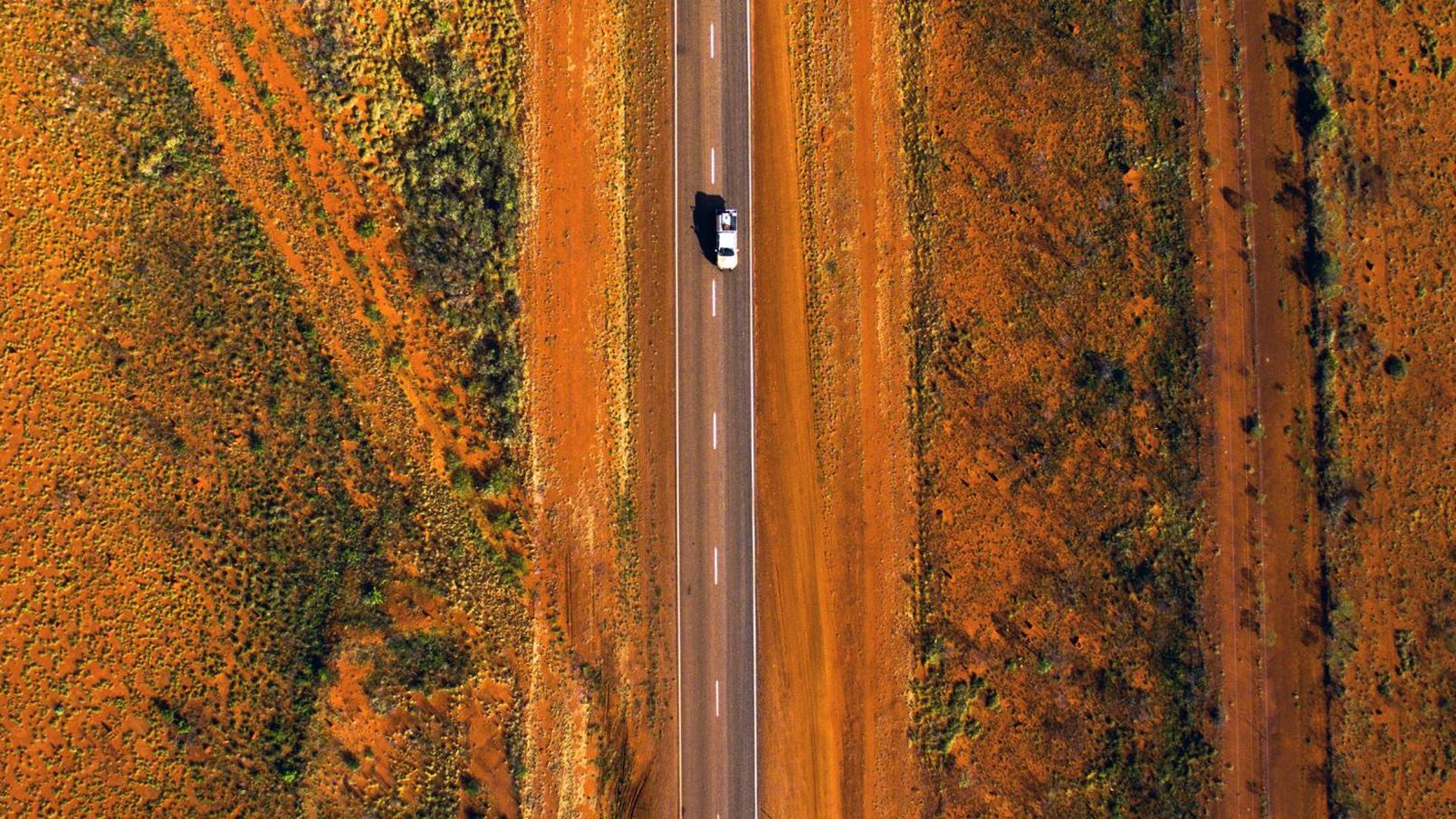 Aerial view of a 4WD driving on the Stuart Highway through the desert landscape near Alice Springs NT