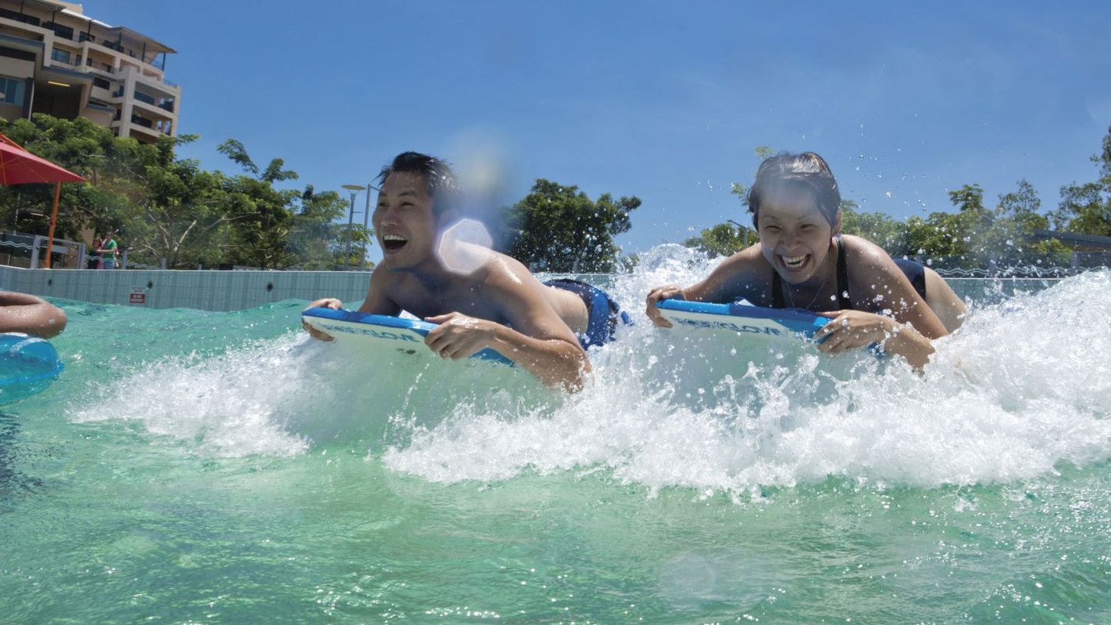 People riding on body boards in the wavepool at Darwin Waterfront.jpg