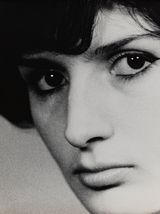 Nahaufnahme eines Schwarz-Weiß-Porträts einer Person mit kurzen dunklen Haaren und intensivem Blick, die leicht zur Seite schaut.