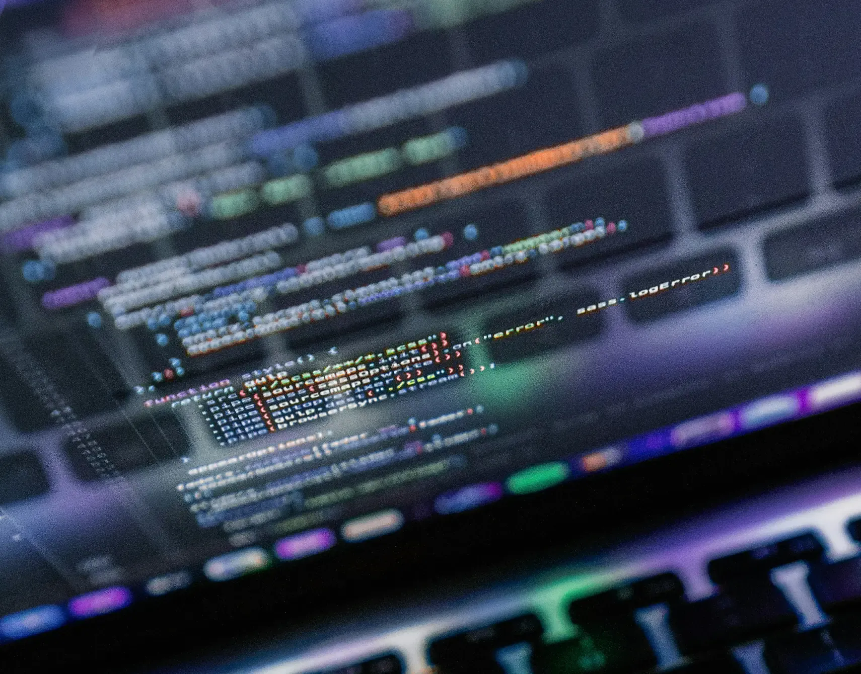 Close-up of a laptop screen showing lines of code above a backlit keyboard, representing metadata in real-world use cases