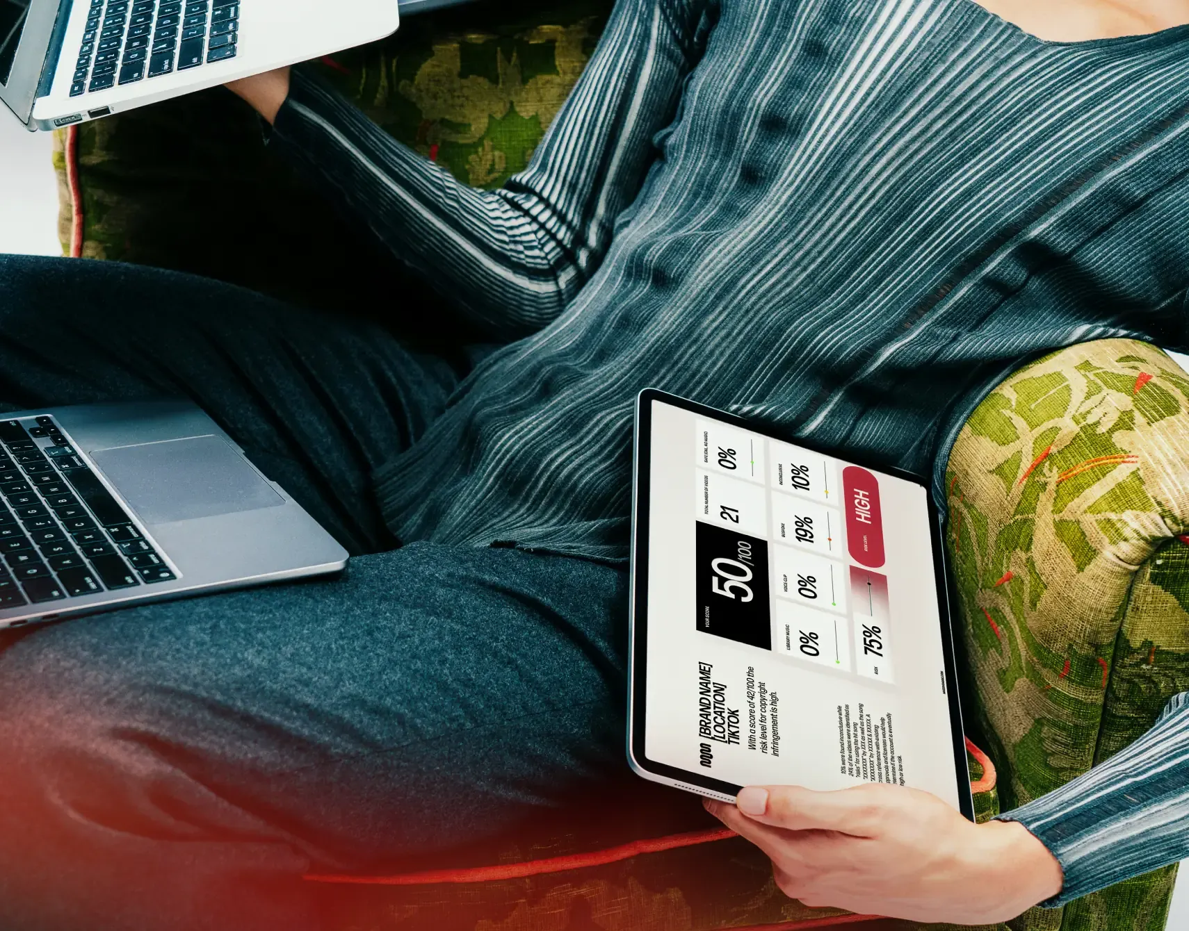 Person on a sofa reviewing music compliance risk scores on a tablet, monitoring brand content across channels