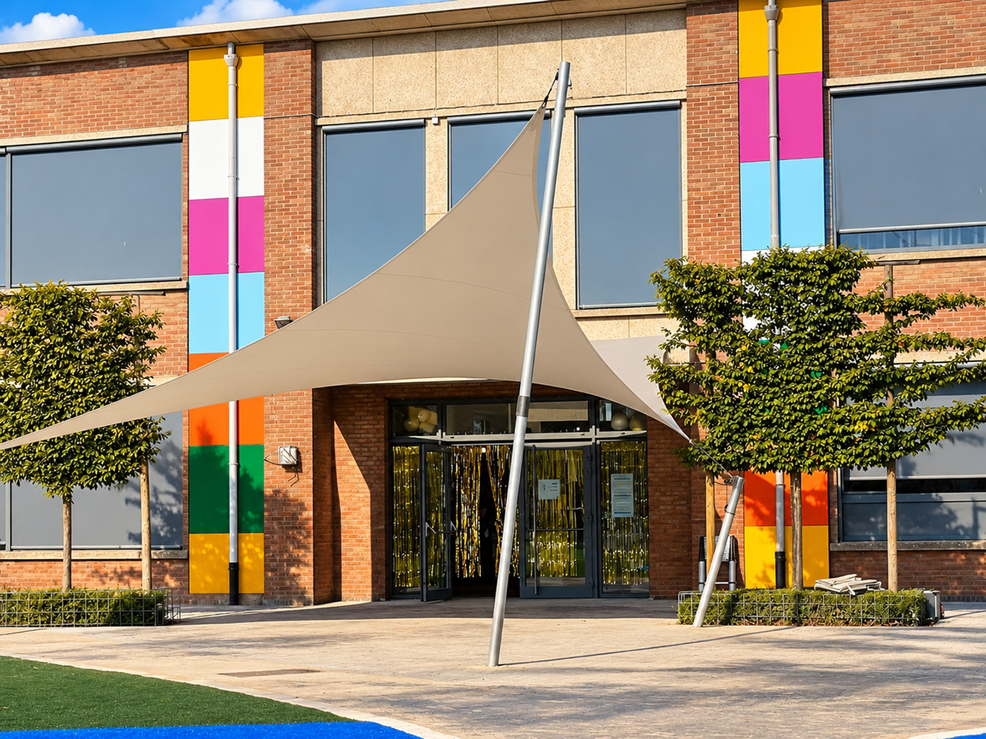 Architectonische textieloverkapping van Mobuline bij de entree van een schoolgebouw, ontworpen als maatwerk schaduwvoorziening voor het schoolplein.