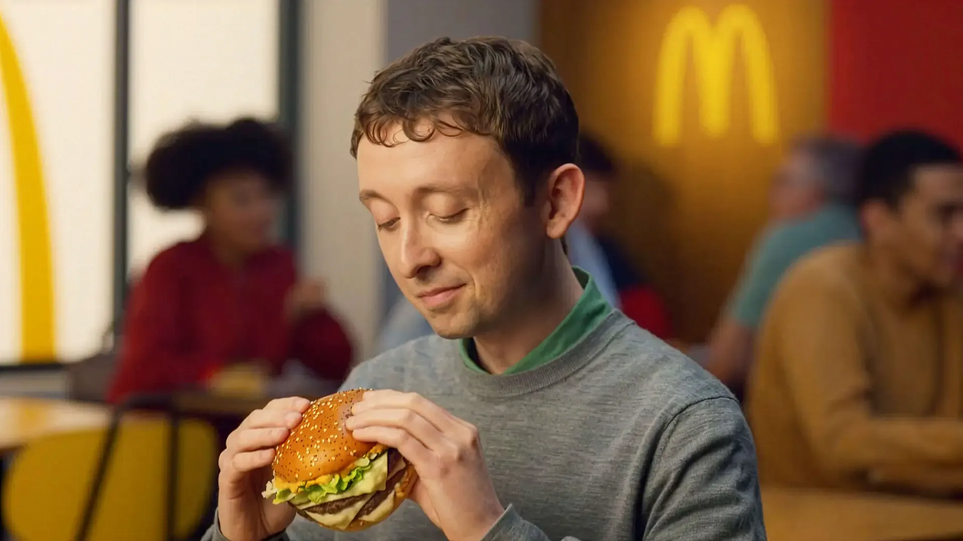 Man biting into a McDonald's Big Arch burger in a restaurant, from the Sound of McDonald's campaign