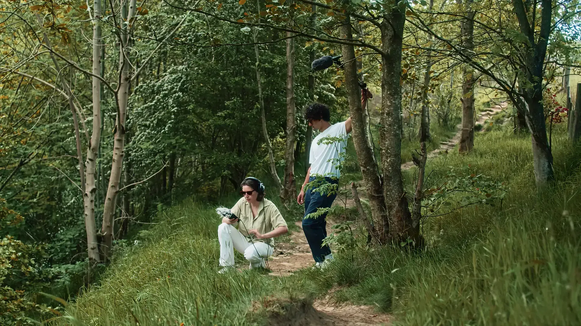 Two recordists with headphones and a boom mic capturing woodland sounds for the Sound of National Trust