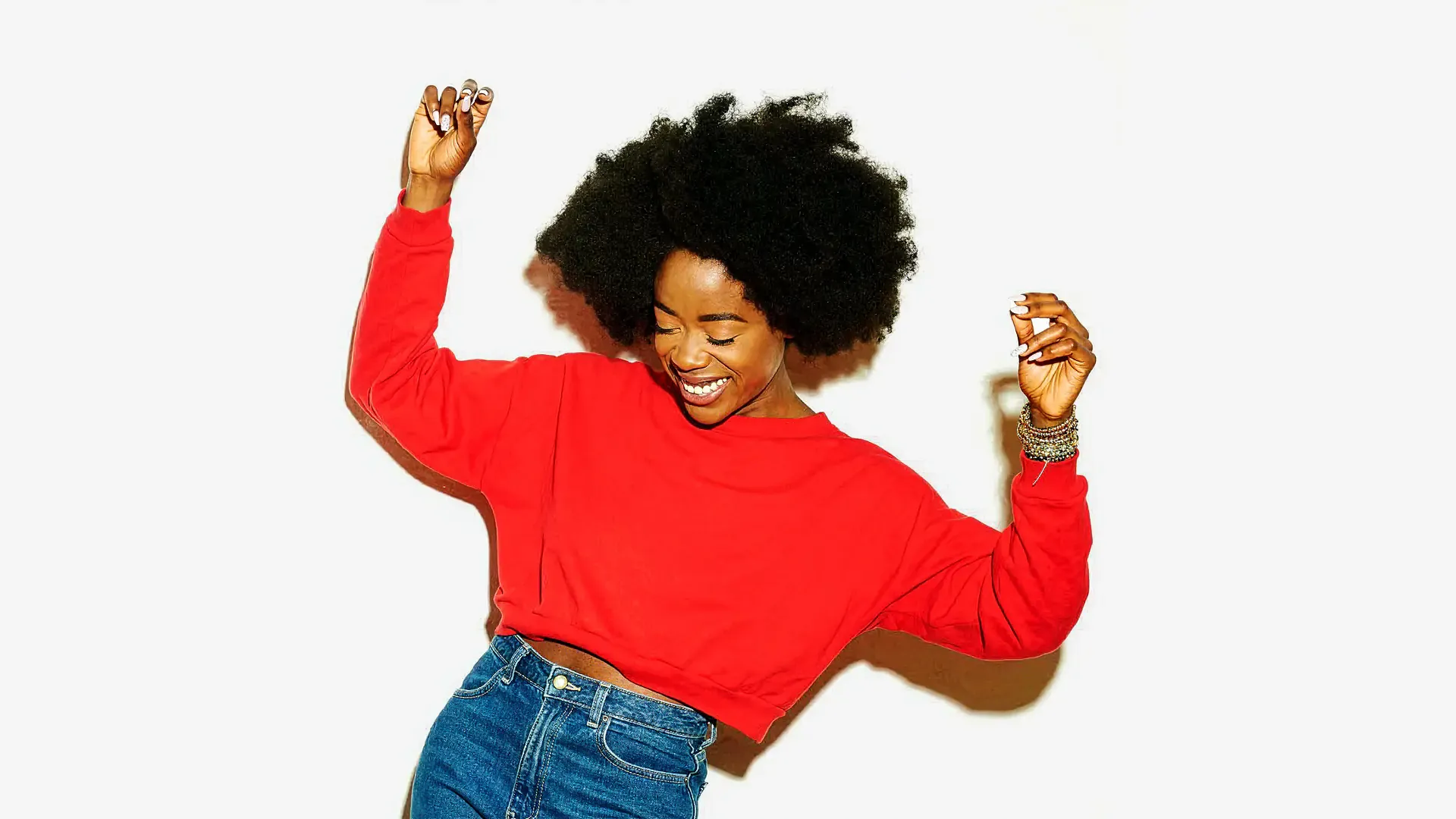 Woman in a red top dancing against a white background, from the Sound of Colgate campaign