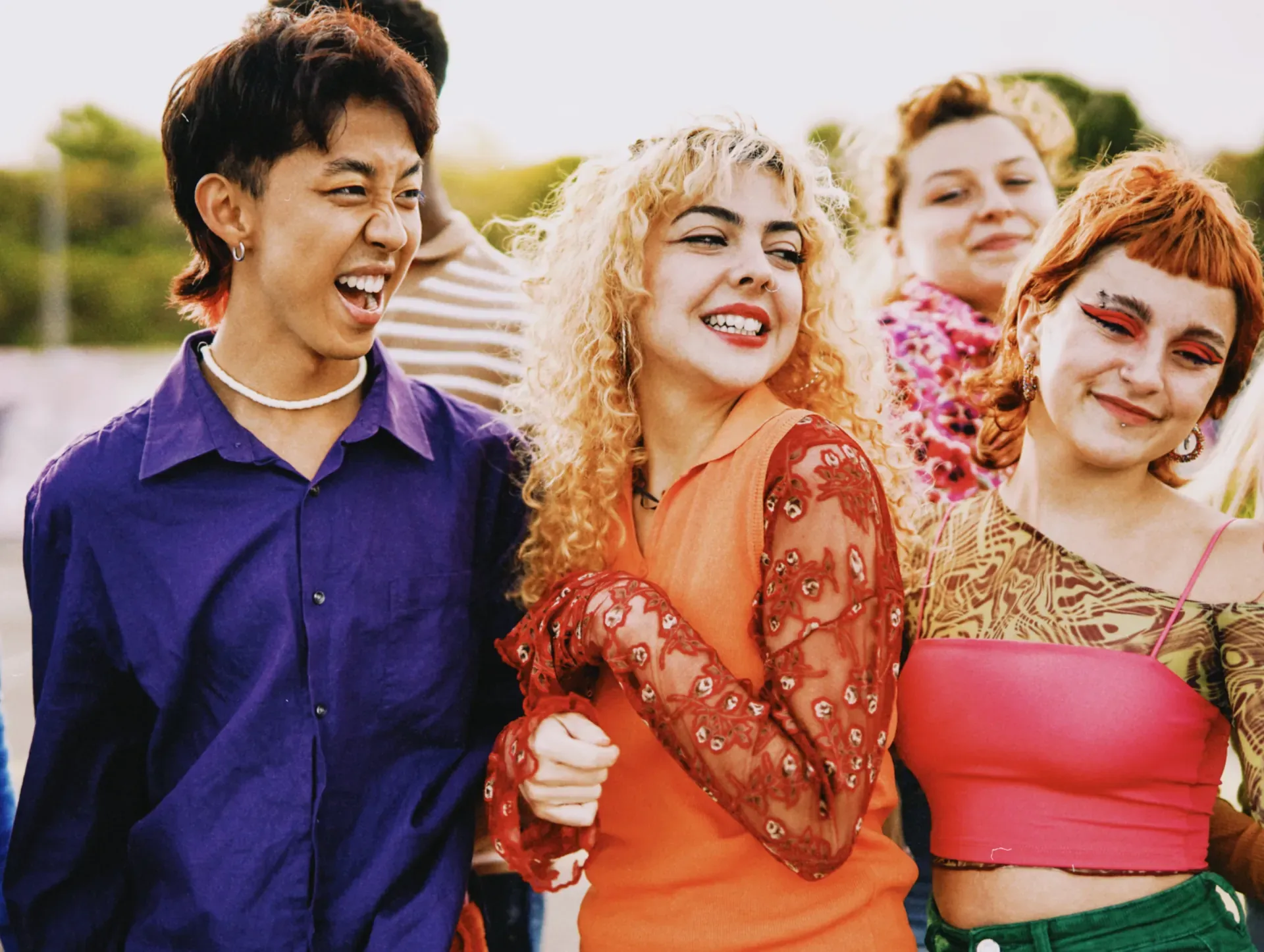 Group of laughing friends in colourful outfits, the younger generation GRAI's social streaming service is made for