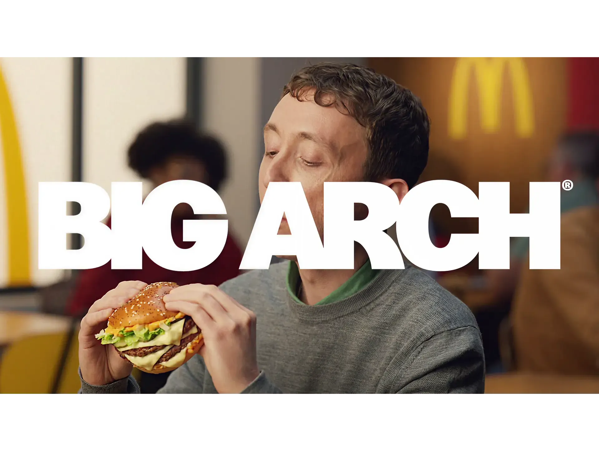 Big Arch title over a man eating a McDonald's burger by the golden arches, Sound of McDonald's