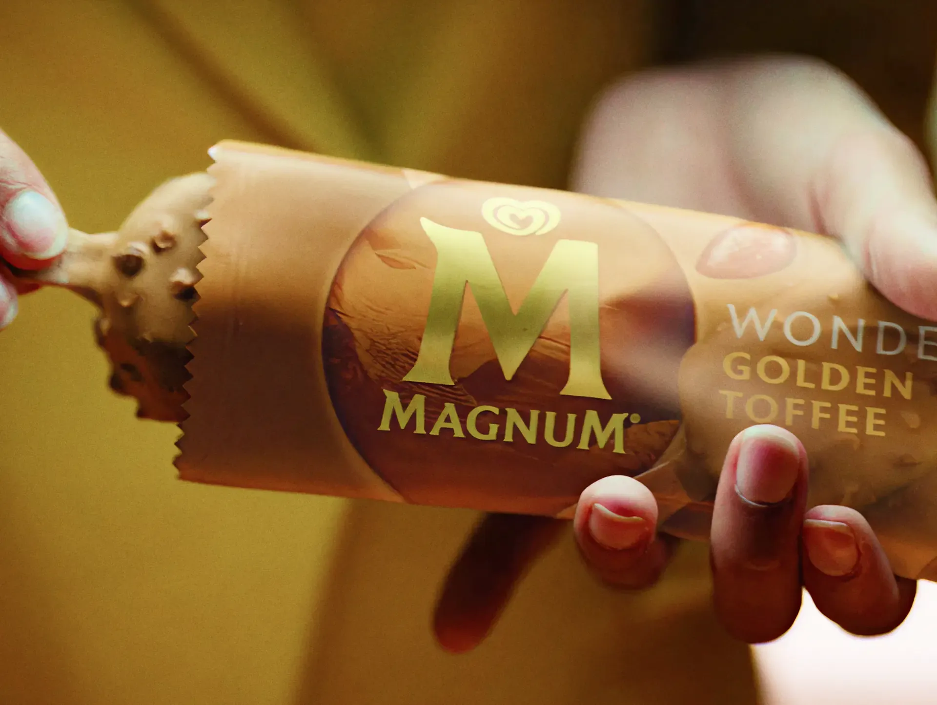 Hand holding a Magnum Wonder Golden Toffee cone, from the Sound of Magnum campaign