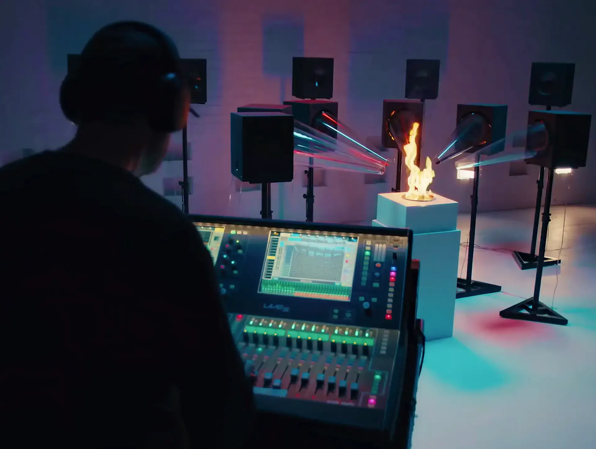 Sound engineer at a mixing desk beside a flame and studio speakers, from the Sound of CRA campaign