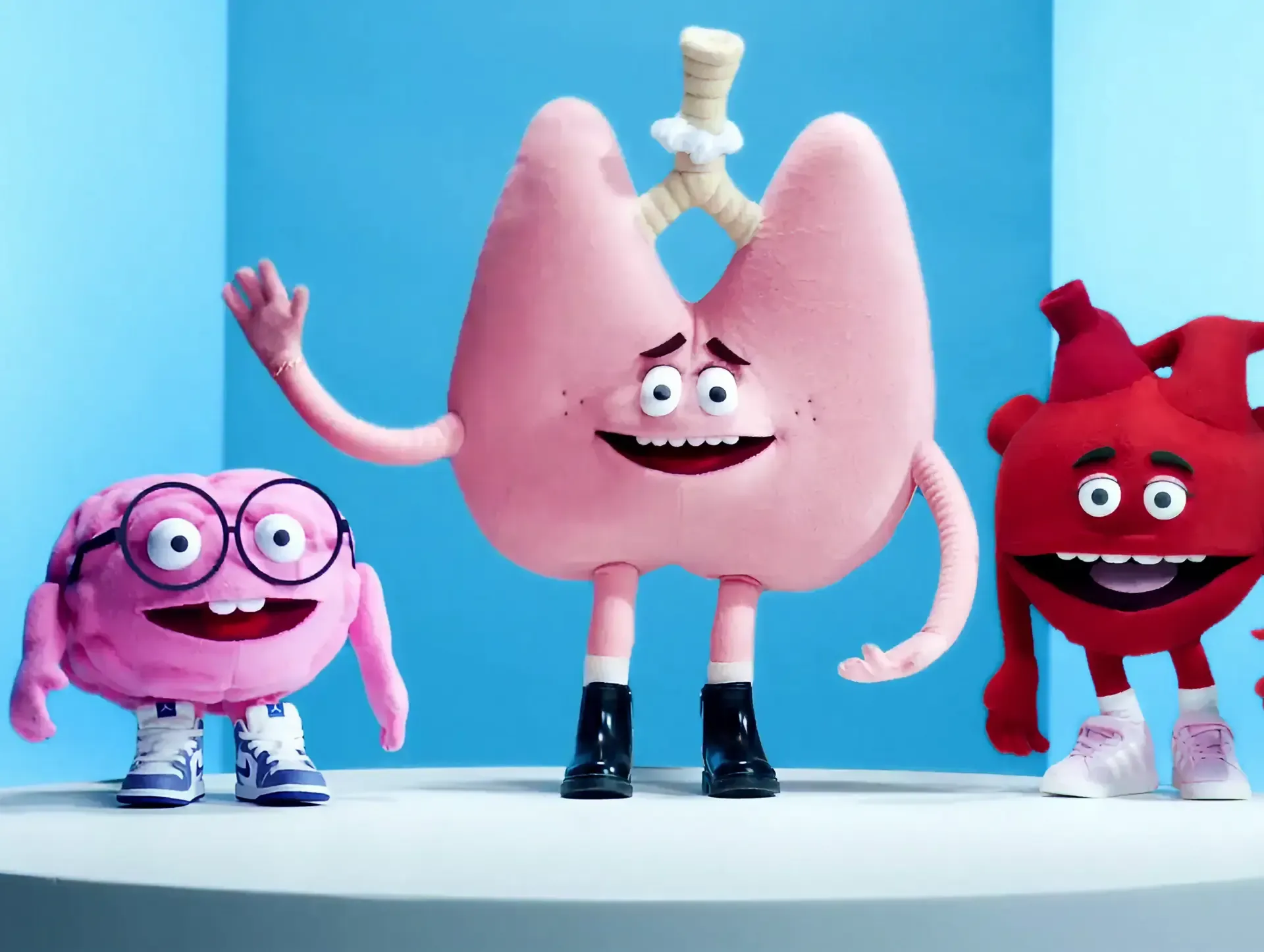 Lung puppet waving beside a small heart and brain puppets on blue, from the Dutch Ministry of Health anti-vaping campaign