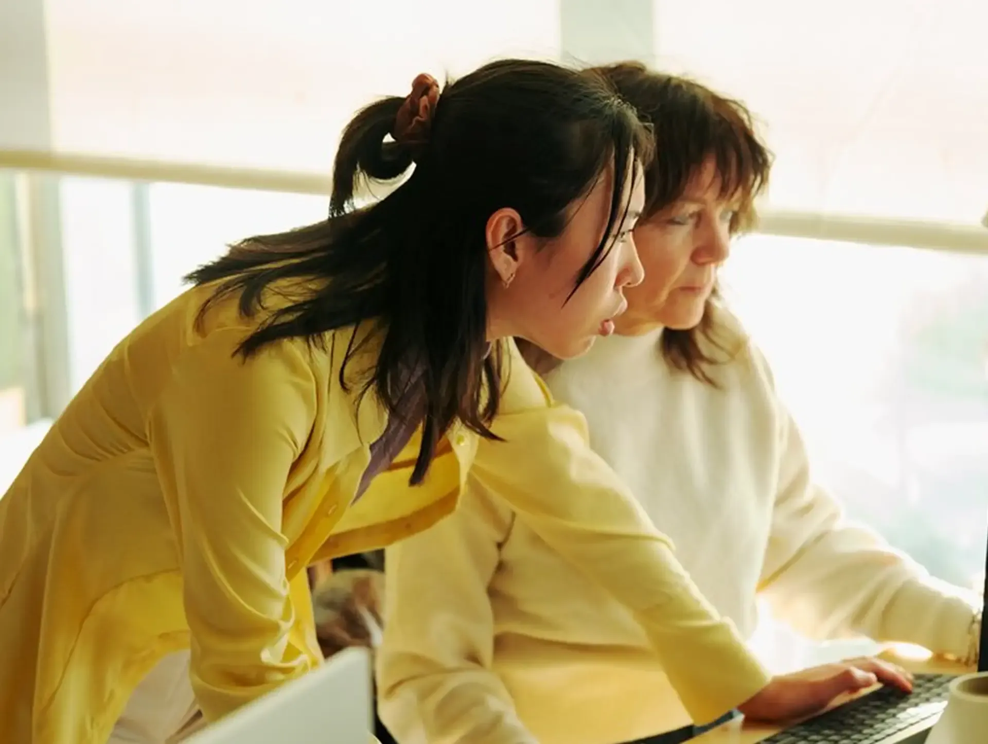 Clinician and patient reviewing health data on the Heidi platform together on a laptop in a bright, sunlit room, experiencing the clear, confident brand sounds.