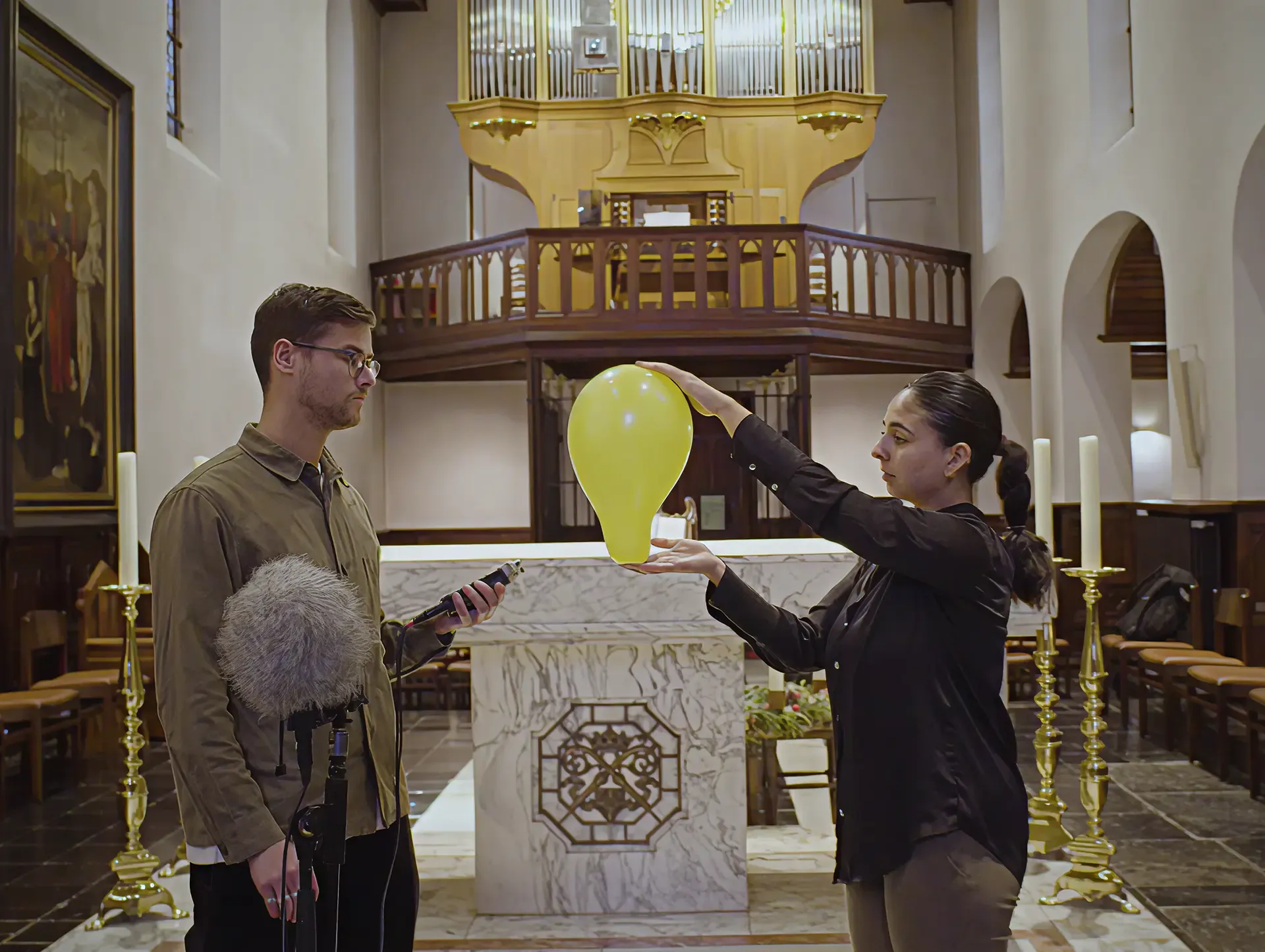 Two people recording sound beside the organ in a Leffe abbey, from the Sound of Leffe campaign