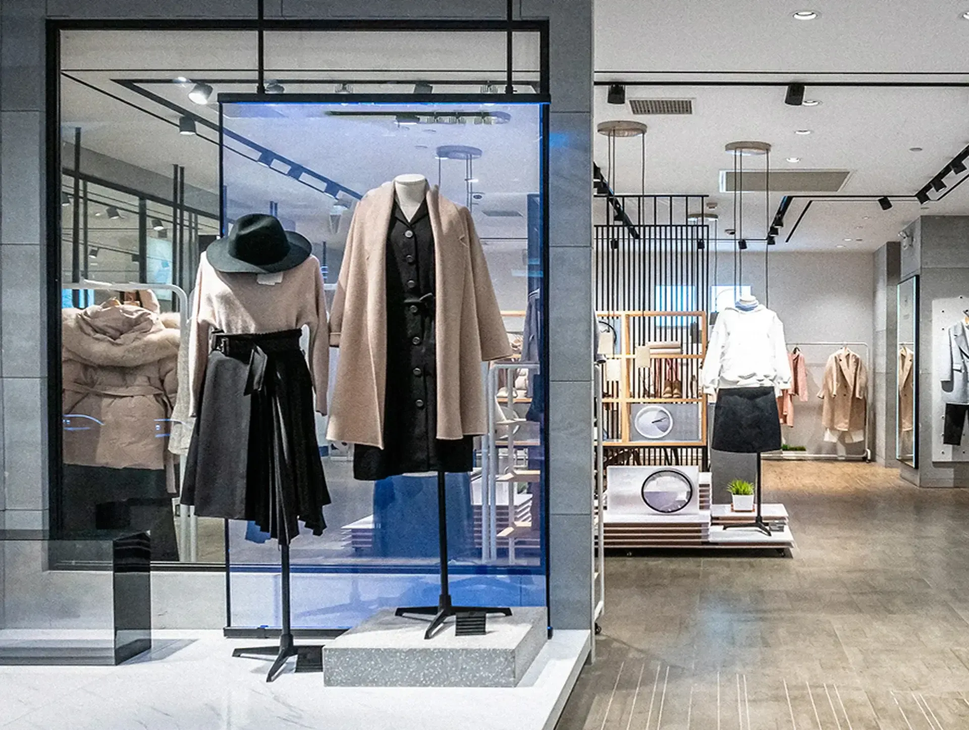 Inside view of a clothing retail store with mannequin displays and lit fitting areas creating a calm shopping mood