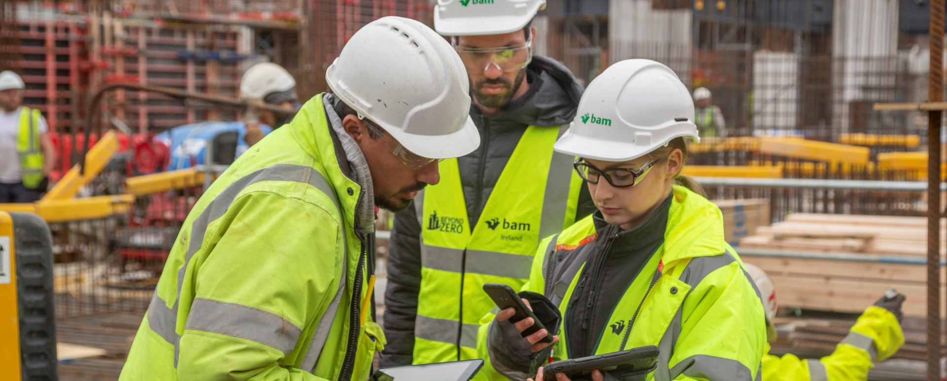 Construction workers on site using construction management software to improve performance.