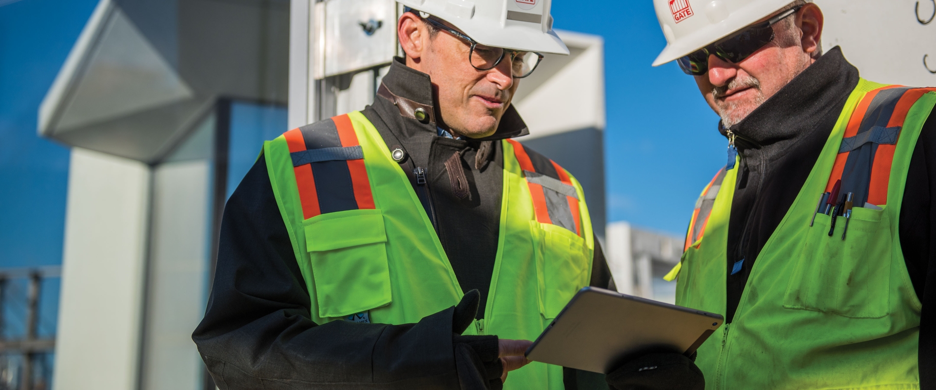 Two construction site managers discuss construction cost management software