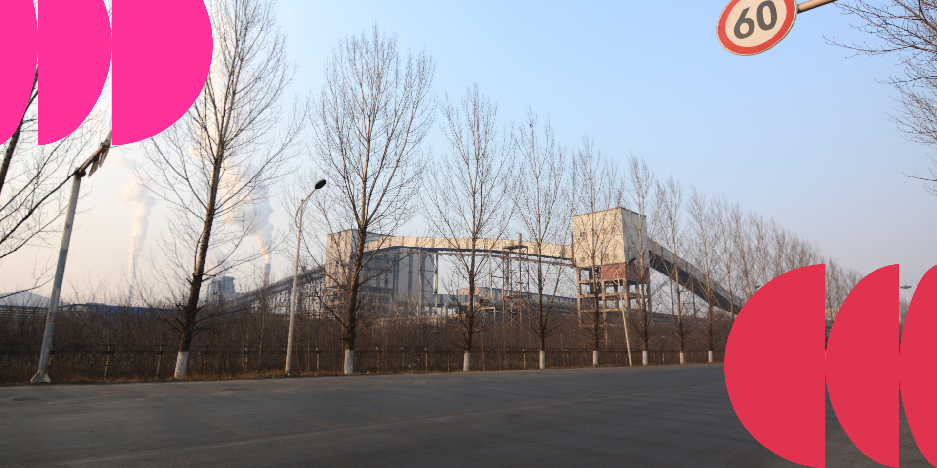 Industrial building behind leafless trees with a 60 km/h speed sign and pink graphic elements on the sides.