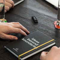 Abstraction-notitieboek met de tekst ‘ideas beyond boundaries’ tijdens een overleg.