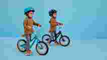 Two kids playing around on a Raleigh bike