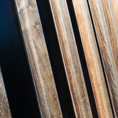 Gevelbekleding in hout, type padouk.  Bevestigd op aluminium draagstructuur.  Structuur opgebouwd met aluminium voeglatten.
