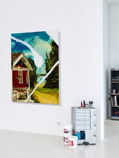 image of a painting of a red house hanging in a studio