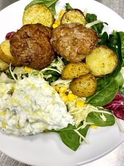 Klimatsmarta grekiska biffar serveras med tzatziki och örtrostad potatis