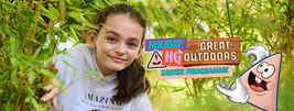 Young girl smiling while crouching among green bushes. Overlaid text reads "Holiday HQ: The Great Outdoors Easter Programme" with a cartoon character.
