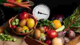 Vegetables and fruit in baskets, with a set of weighing scales