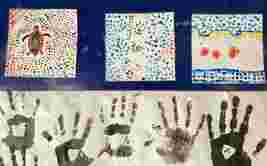 Three colorful dot paintings and multiple black handprints on paper displayed against a blue background.