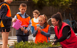 Kids outdoors watering plants