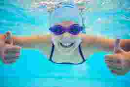 Child smiling under water in a swimming pool