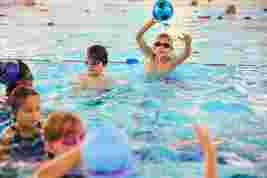 Children playing with a ball in the swimming pool