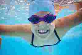 Child smiling under water in a swimming pool