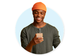 man in orange hat smiles at phone after receiving great CX