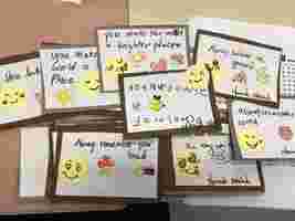 Handmade cards with positive messages and smiling emoji drawings, featuring phrases like "You make the world a brighter place" and "Always believe in yourself."