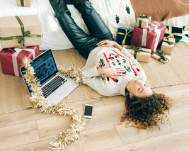 Woman rests beside presents whilst Christmas shopping