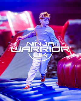 Child in grey tracksuit navigating an inflatable obstacle course with "Ninja Warrior UK" logo overlay.
